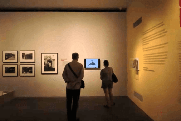 Visitors viewing photographic artworks and multimedia displays inside The Photographers’ Gallery in London, featuring framed photographs, exhibition panels, and contemporary visual storytelling.