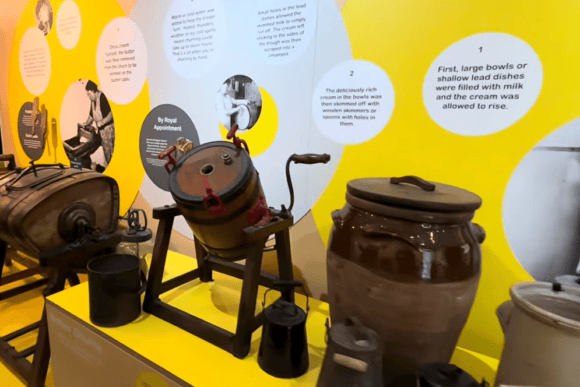 Historic butter and cream-making equipment displayed at Wensleydale Creamery Visitor Centre, with educational panels explaining traditional dairy production in Yorkshire.