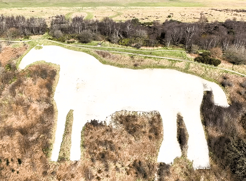 Aerial view of the White Horse of Kilburn carved into the hillside of the North York Moors, surrounded by woodland and open countryside.