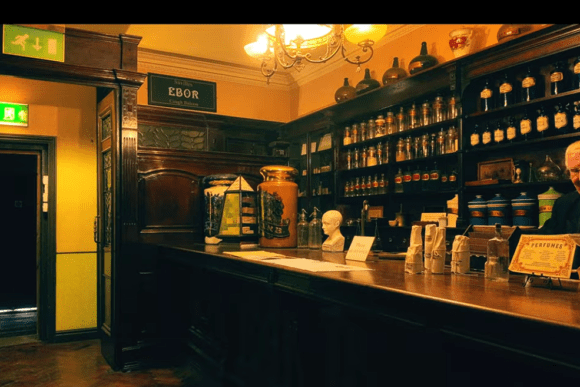 Recreated Victorian pharmacy inside York Castle Museum featuring traditional wooden counters, antique medicine bottles, apothecary jars, and a costumed pharmacist demonstrating 19th-century healthcare.
