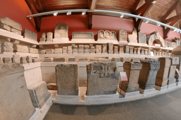 Interior of Chesters Roman Fort and Museum displaying carved Roman stone inscriptions and architectural fragments.