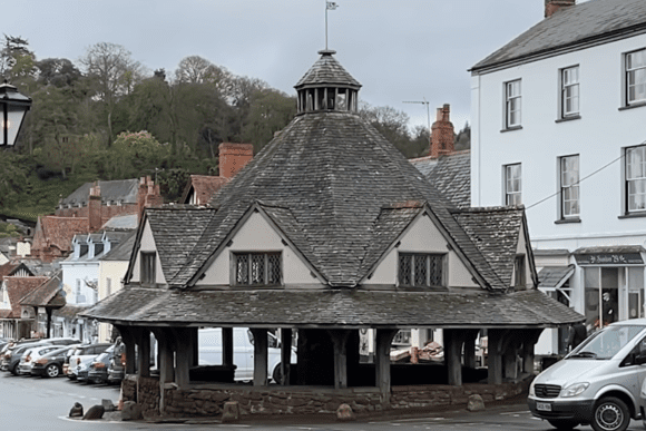 Dunster Yarn Market in the village square, a timber-framed market building with a shingled roof and central cupola.