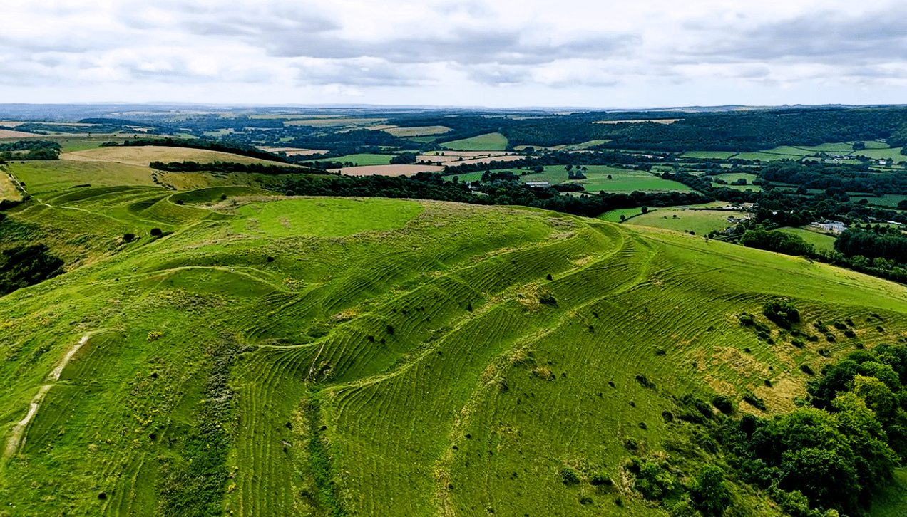 Aerial view of Hod Hill Iron Age hillfort earthworks overlooking the Dorset countryside.