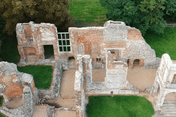 Aerial view of Old Gorhambury House ruins showing brick and stone walls, partial rooms, and surrounding greenery.