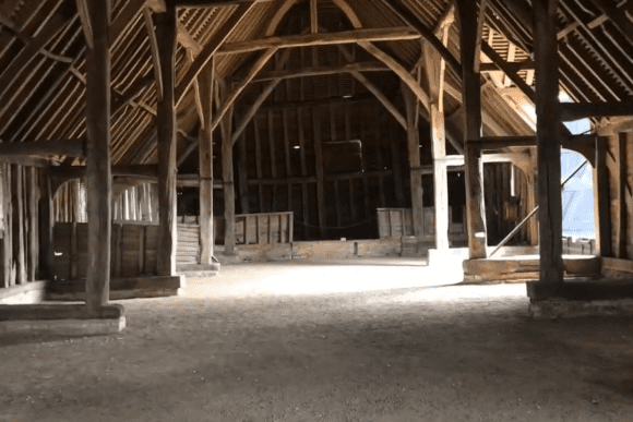 Interior of Prior’s Hall Barn in Essex, England, showing exposed timber beams, wooden framework, and open historic barn space.
