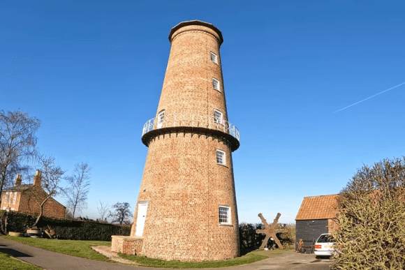 Sibsey Trader Windmill brick tower windmill with circular balcony and surrounding countryside in Lincolnshire.